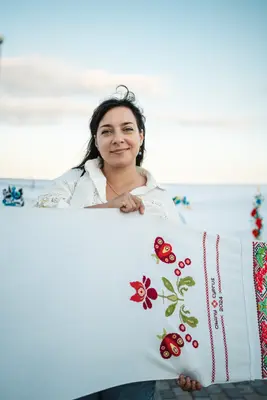 A participant with a panel embroidered with red flowers