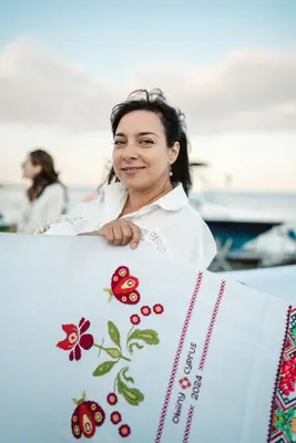 A participant with an embroidered panel by the harbour